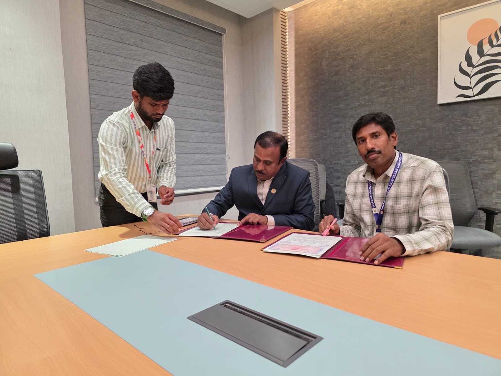 Representatives reviewing and signing documents at a meeting
